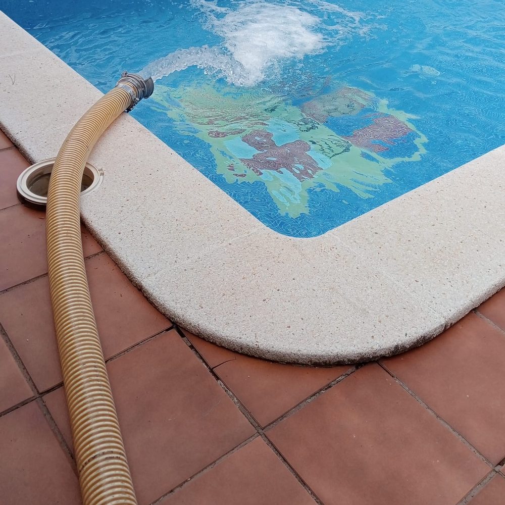 Manguera de la cisterna llenando una piscina con agua potable